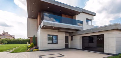 Newly completed custom home exterior with stone and timber accents under a Montana sky