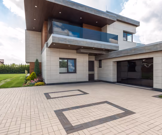 Newly completed custom home exterior with stone and timber accents under a Montana sky