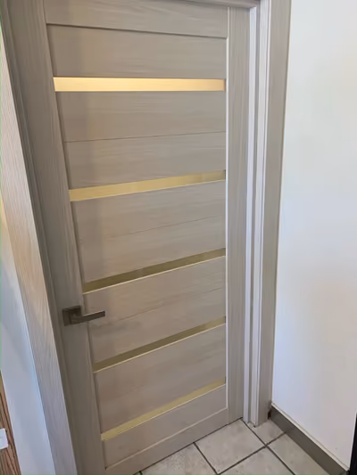 Close-up of an interior door with horizontal frosted-glass inlay strips and a modern lever handle