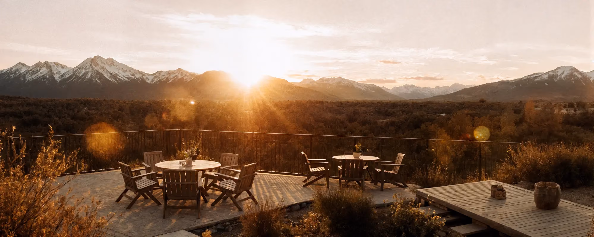 Sunset view of a mountain-backed deck and patio with outdoor seating