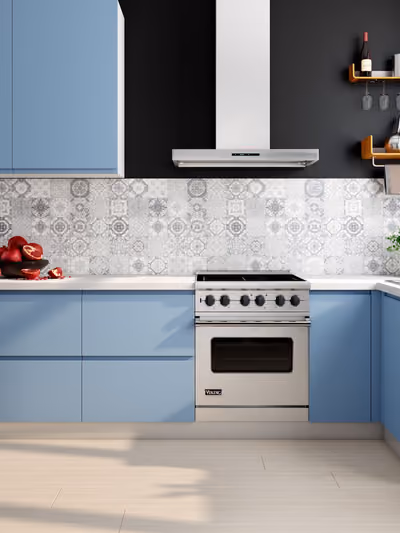 Bold kitchen with slate-blue cabinetry, patterned tile backsplash, and a stainless range