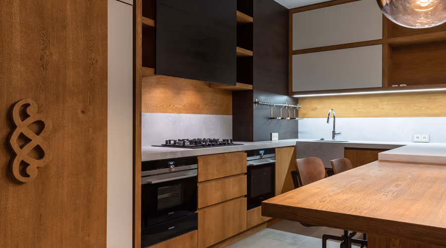 Modern remodeled kitchen with warm wood cabinetry, island seating, and stainless appliances