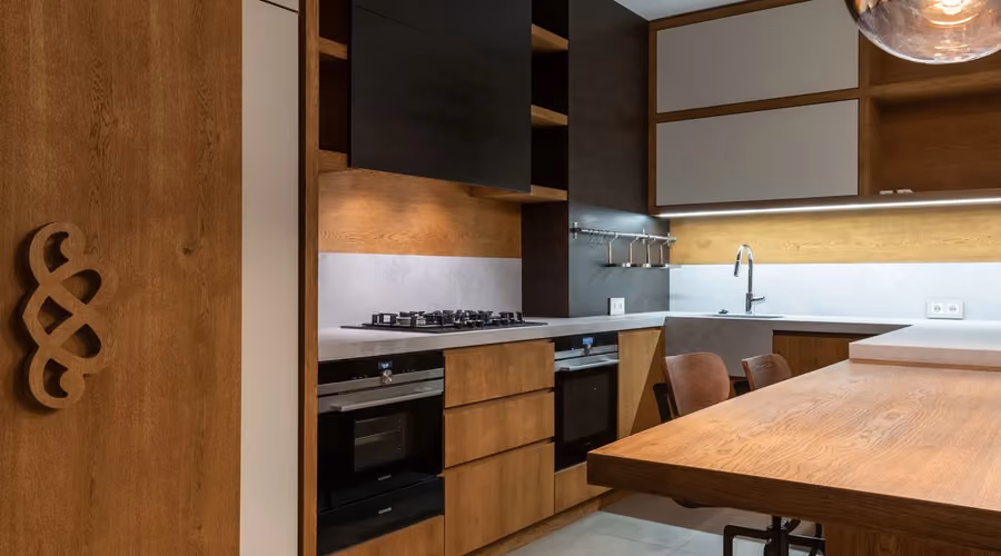 Modern remodeled kitchen with warm wood cabinetry, island seating, and stainless appliances